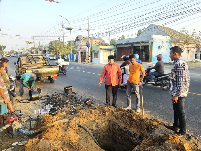 TURUN KE LAPANGAN: Direktur Perumda Sumber Sejahtera Sjobirin Hasan (baju merah) memantau secara langsung perbaikan pipa transmisi utama di Desa/Kecamatan Burneh, Bangkalan. (PDAM UNTUK JPRM)