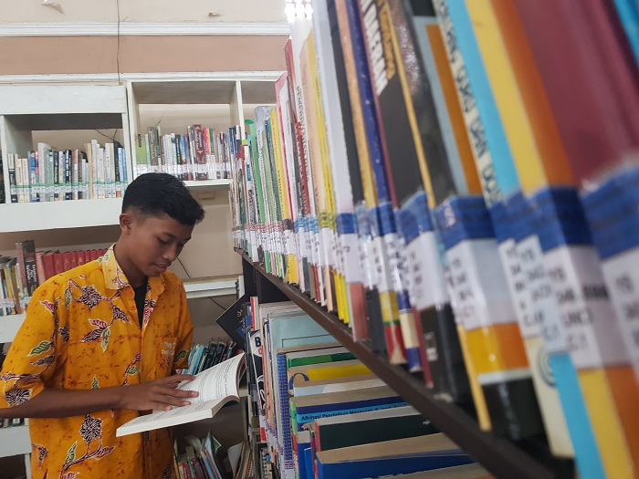 LAILIYATUN NURIYAH/JPRM FOKUS: Syukron, siswa SMKN 2 Pamekasan membaca buku di Perpustakaan M. Tabrani, Kamis (14/12).