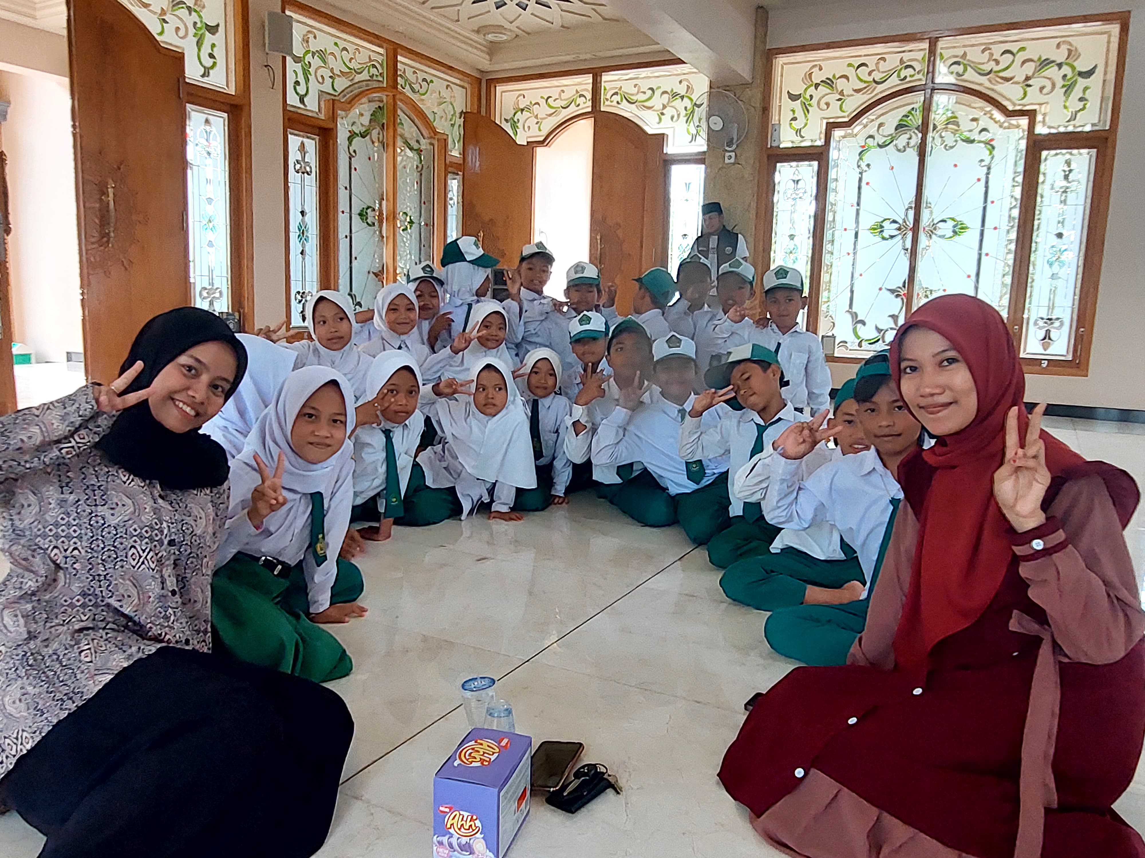 SANTAI : Relawan Madrasah Memanggil Nadiyah Muhimmah dan Siti Ainur Mutmainnah foto bersama siswa di Yayasan Al-Khalili, Desa Bulangan Barat, Kecamatan Pegantenan, Pamekasan, Selasa (12/12).