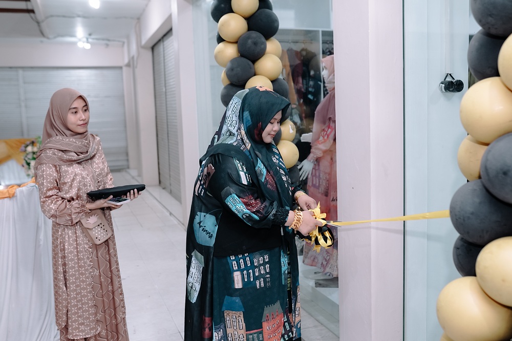 MOMEN PENTING: Arinah Hidayah, owner Arinna Hijab, menggunting pita pada Grand Opening Arinna Hijab Store Ganding, Minggu (10/12) malam. (JAZZ PICTURE UNTUK JPRM)