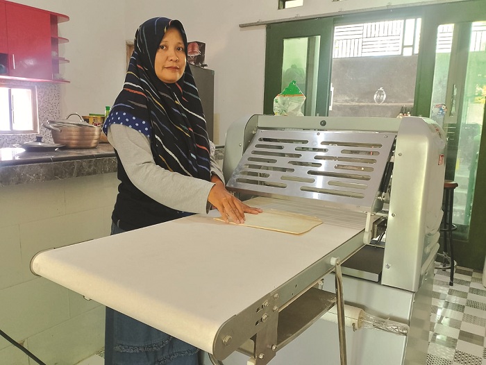 PRODUKTIF: Ruki Hera Wati sedang membuat adonan kue di rumahnya di Kelurahan Kolpajung, Kecamatan Kota Pamekasan, Sabtu (16/12). (UBAIDILLAHIR RA&rsquo;IE/JPRM)