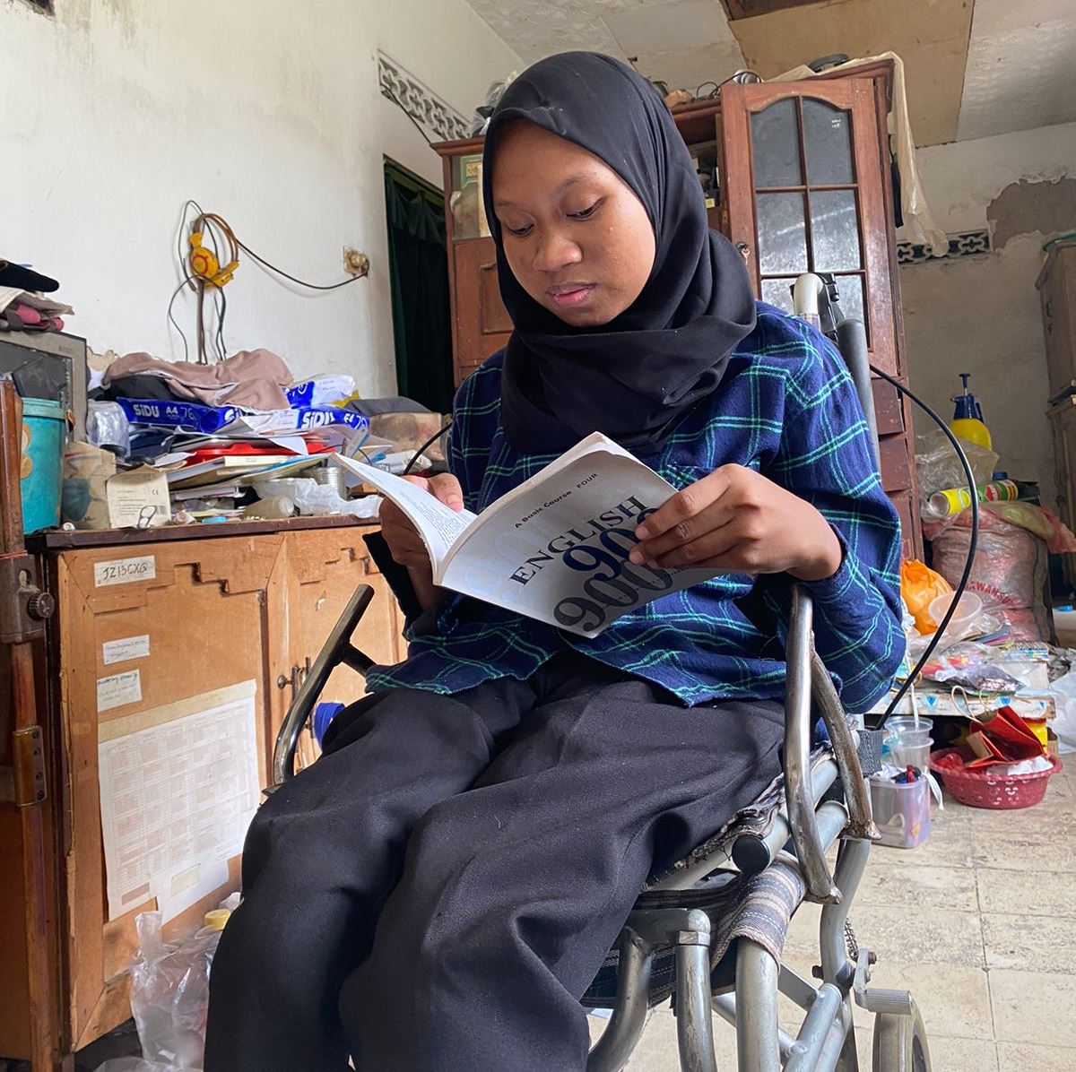 PENUH SEMANGAT: Sahmul Lailah membaca buku di rumahnya di Kelurahan Pejagan, Kecamatan Kota Bangkalan, Rabu (13/12). (AYU LATIFAH/JPRM)
