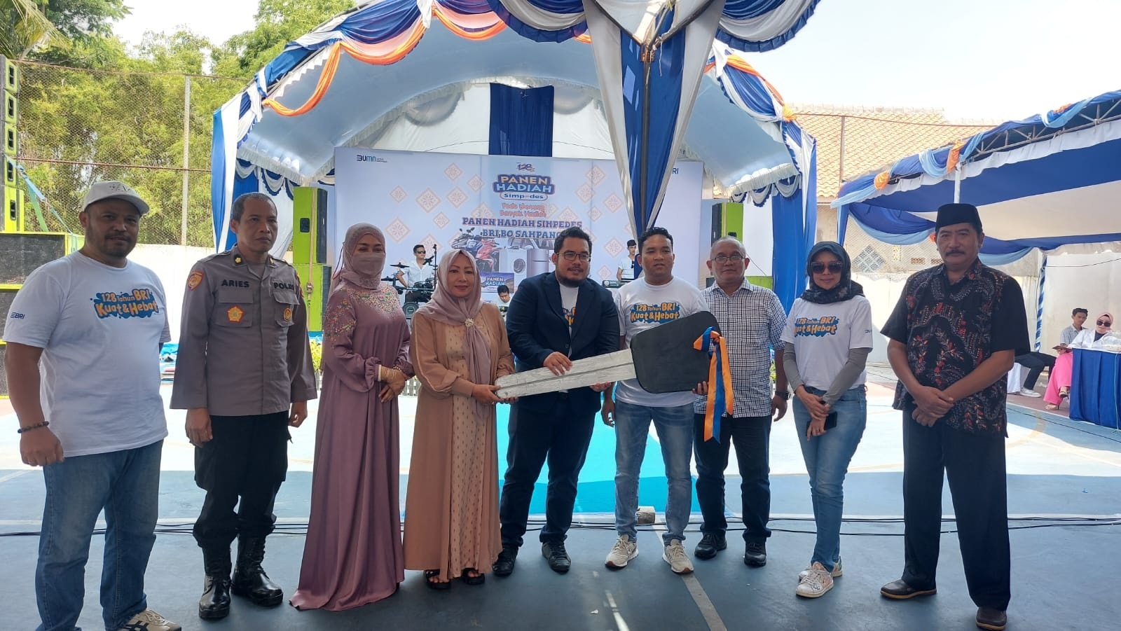 SIMBOLIS: Branch Manager BRI Sampang Rahmat Salim (tengah) menyerahkan replika kontak mobil kepada perwakilan nasabah yang menang dalam acara PHS di lapangan kantor BRI Cabang Sampang, Sabtu (16/12).