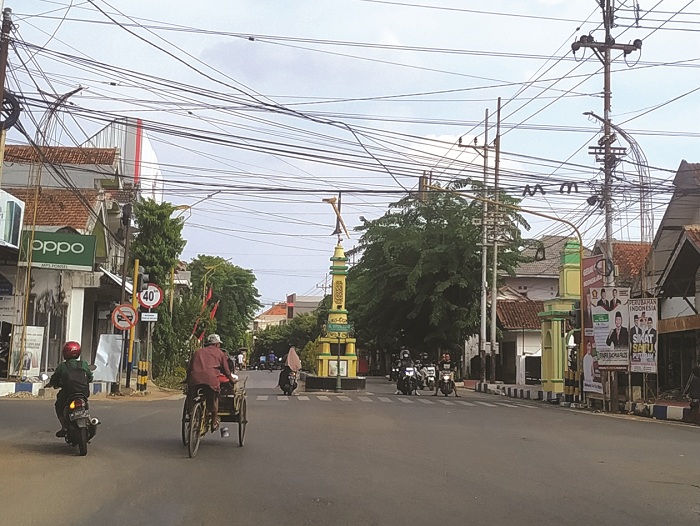 TUGU KERIS: Warga melintas di bangunan tugu yang terletak di jalan raya simpang empat (perempatan) Senin (18/12). (HERIVIYA YUVI/JPRM)