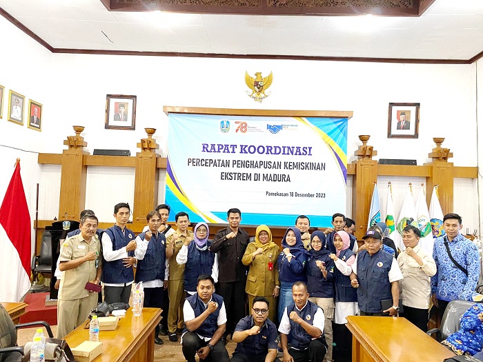 BERSINERGI: Kepala Bakorwil IV Pamekasan Sufi Agustini (tengah, berseragam dinas) berfoto bersama peserta rakor percepatan penghapusan kemiskinan ekstrem Senin (18/12). (MOH. JUNAIDI/JPRM)