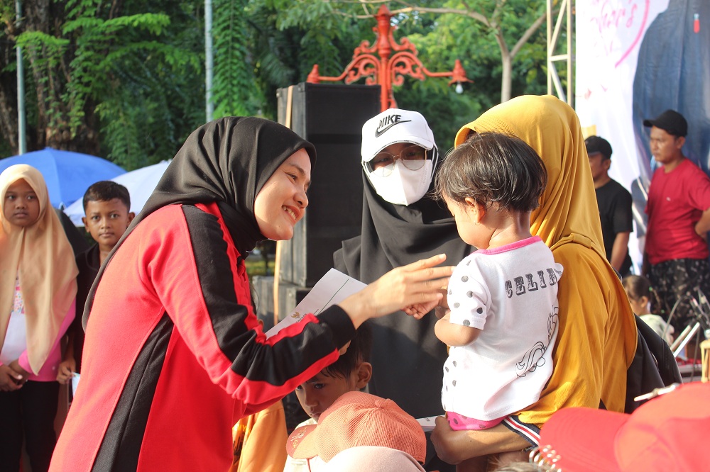 PENYAYANG: Ketua Perwosi Sumenep Nia Kurnia Fauzi (kiri) memberikan santunan kepada anak yatim di sela-sela acara JJS Hari Ibu di sisi timur Taman Bunga Pottre Koneng, Minggu. (ERWIN/JPRM)