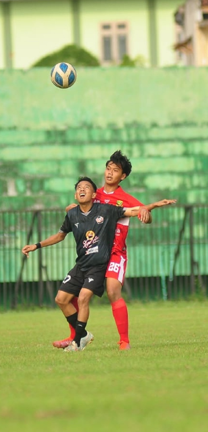 SAMA KUAT: Pemain Perssu Madura City (jersei merah) menutup ruang bagi pemain Persepam Pamekasan (jersei hitam) untuk membangun serangan saat bertanding di Stadion A. Yani Sumenep pada Minggu (17/12).