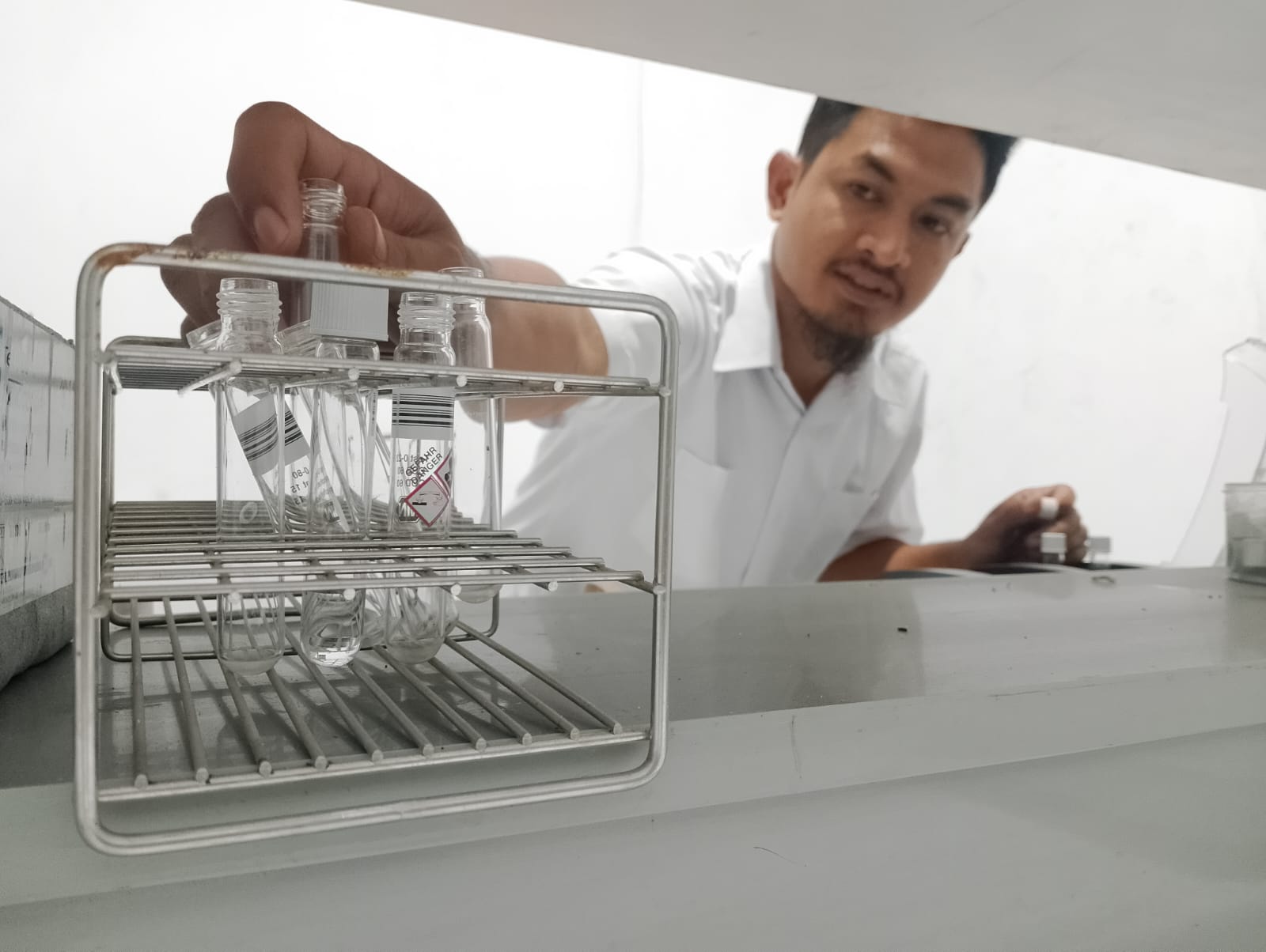 MUBAZIR: Karyawan memantau peralatan di laboratorium DLH Pamekasan, Selasa (19/12). (UBAIDILLAHIR RA&rsquo;IE/JPRM)
