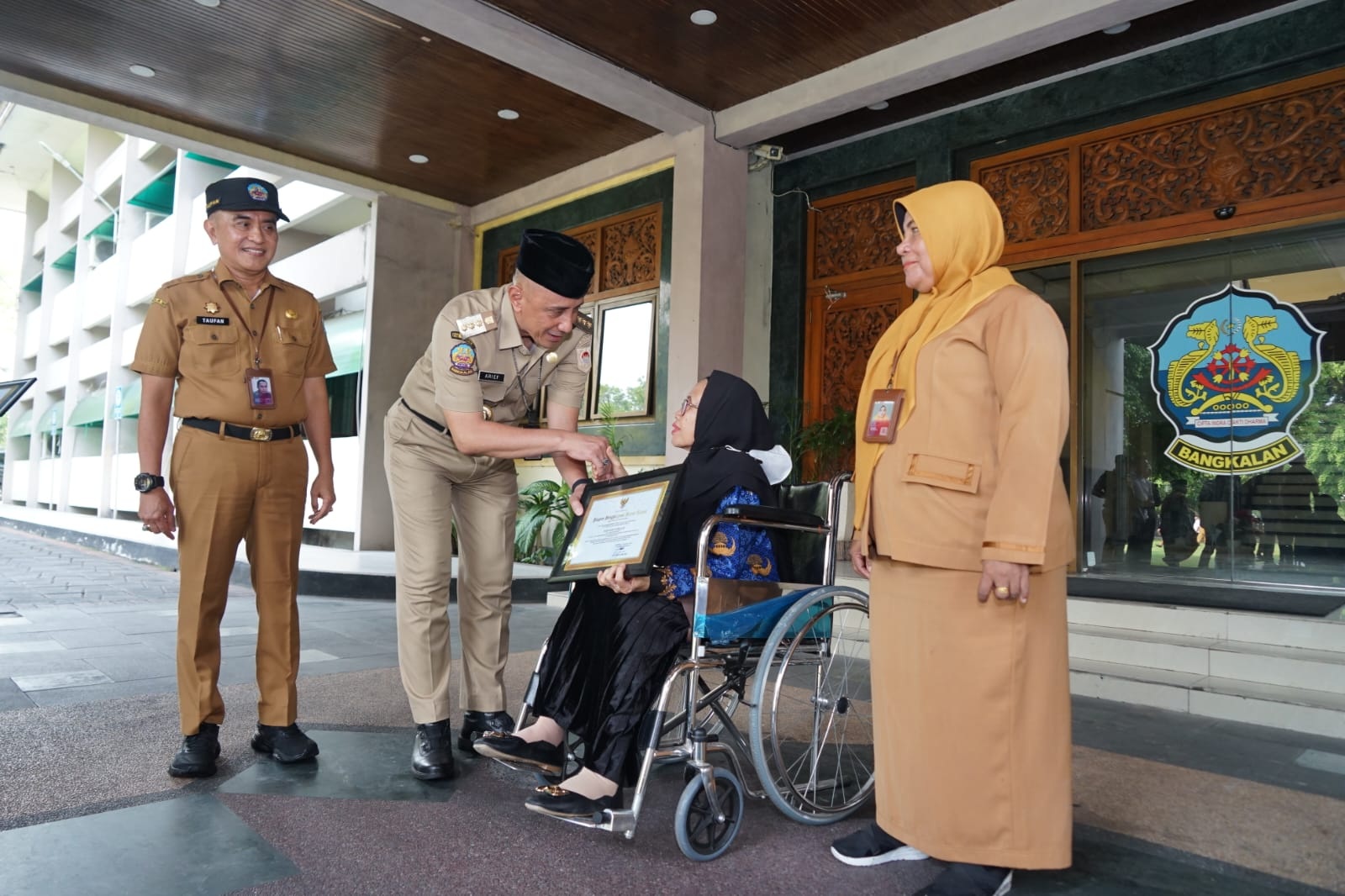 APRESIASI: Pj Bupati Bangkalan Arief M. Edie didampingi Sekkab Moh. Taufan Zairinjah memberikan piagam penghargaan kepada salah seorang ASN yang akan memasuki usia pensiun, Minggu (18/12).