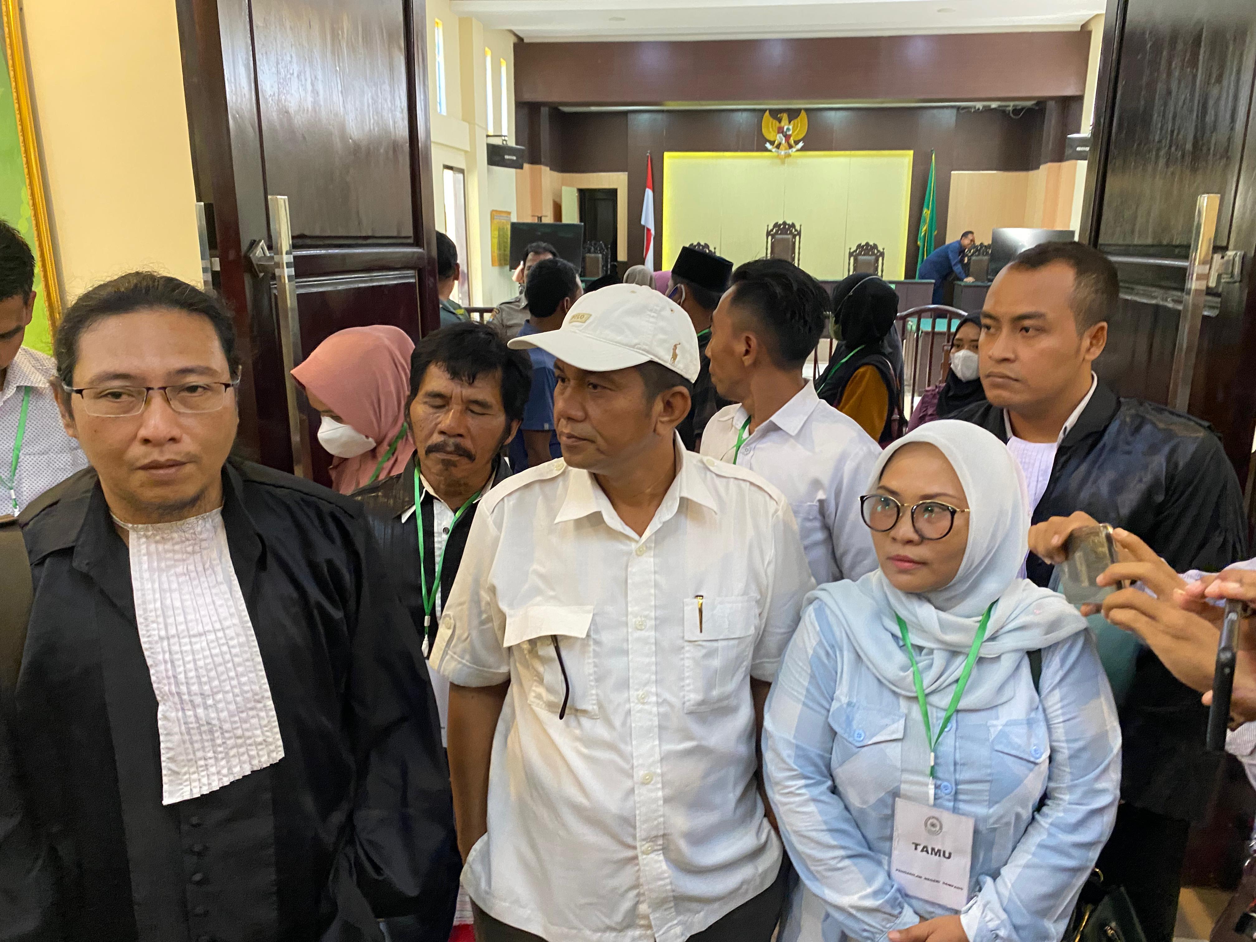 BERI PENJELASAN: Fauzan Adima (topi putih) didampingi istri dan kuasa hukumnya menghampiri wartawan di PN Sampang, Selasa (19/12). (MOH. IQBAL AFGANI/JPRM)