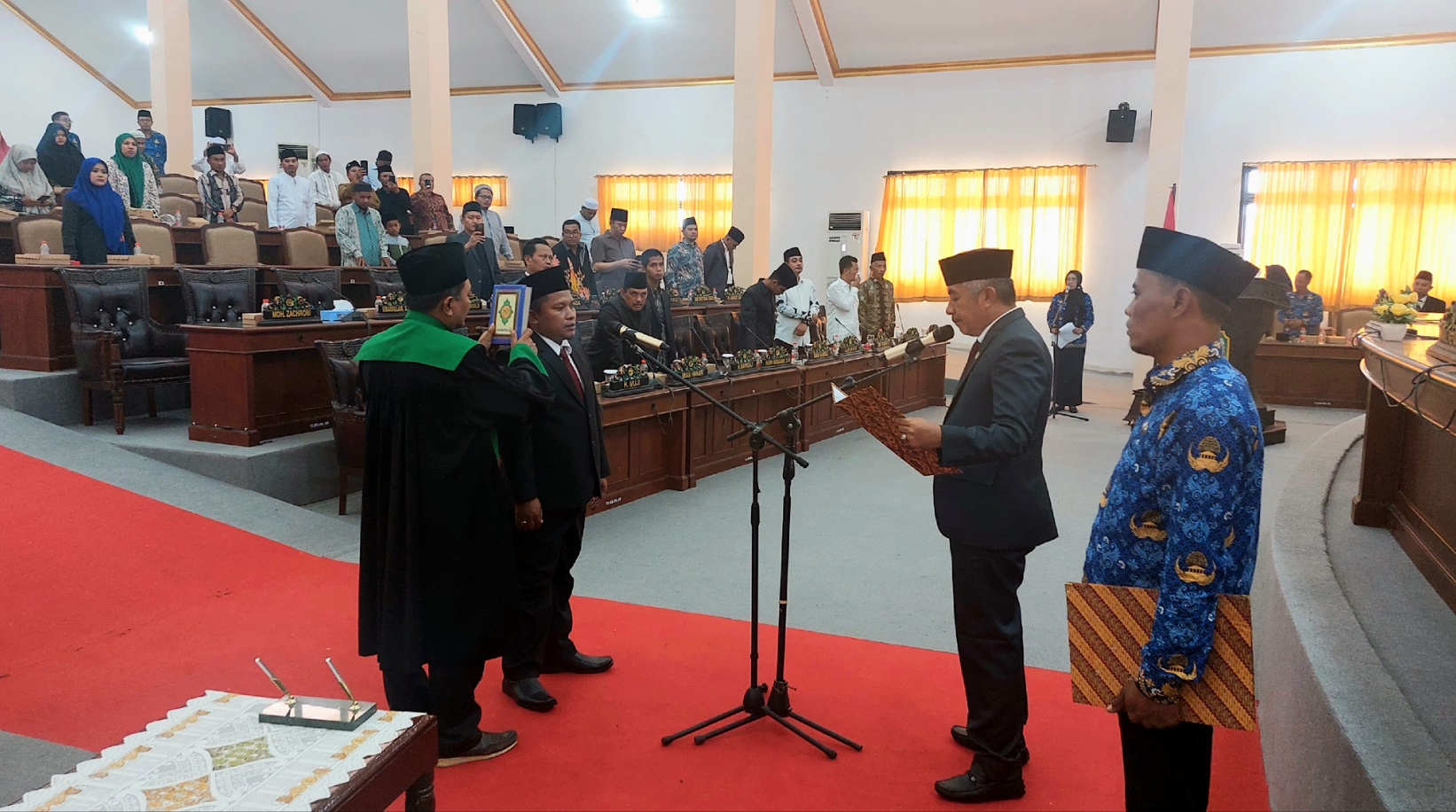 DISUMPAH: Wakil Ketua DPRD Sampang Amin Arif Tirtana (baca map) melantik Ulul Albab (di bawah Al-Qur&rsquo;an) di kantor DPRD Sampang, Senin (18/12). (JUNAIDI PONDIYANTO/JPRM)