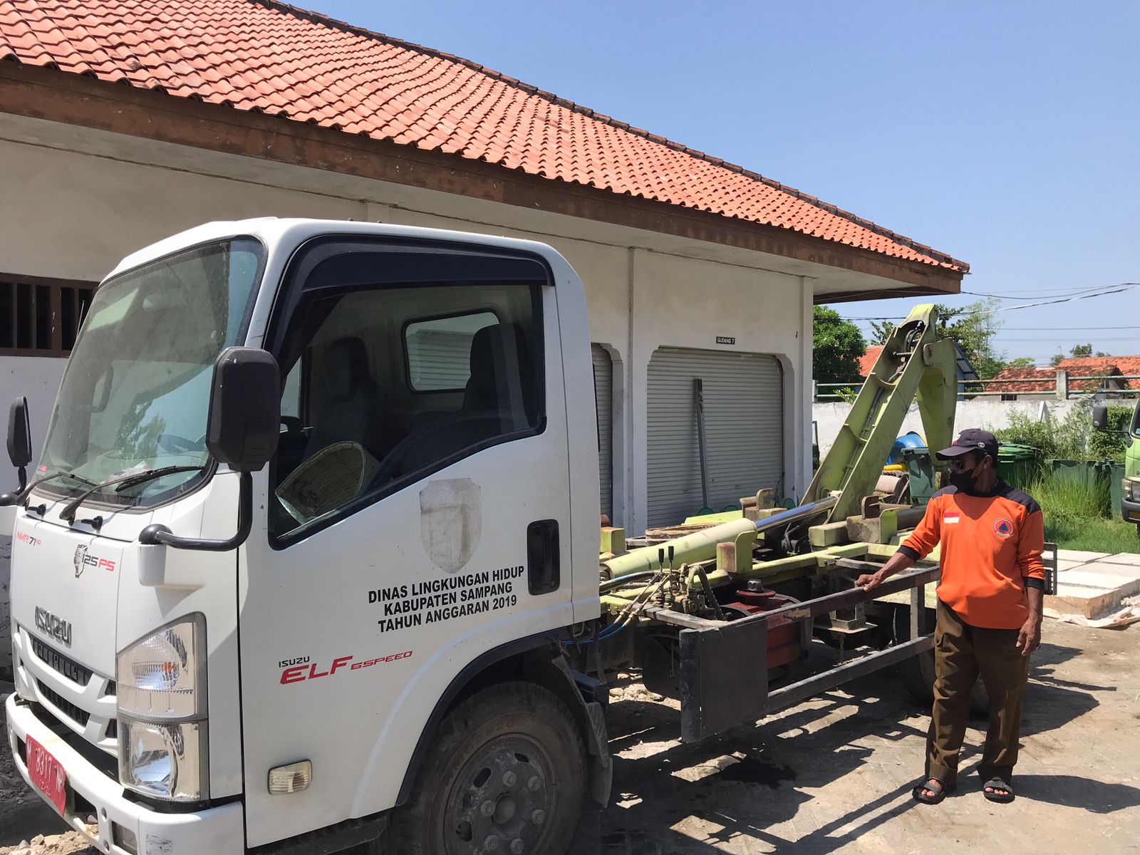 TAK CUKUP ANGGARAN: Pegawai berada di samping truk arm roll yang terparkir di kantor DLH Perkim Sampang. (FERRY ANGGRYAWAN UNTUK JPRM)