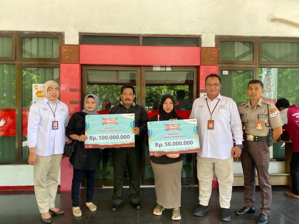 BERTABUR HADIAH: PGS Pemimpin Cabang Bank Jatim Pamekasan Iwan Arief Yudhianto (dua dari kanan) berfoto bersama dengan dua nasabah penerima undian tabungan Simpeda, Rabu (20/12). (MOH. JUNAIDI/JPRM)