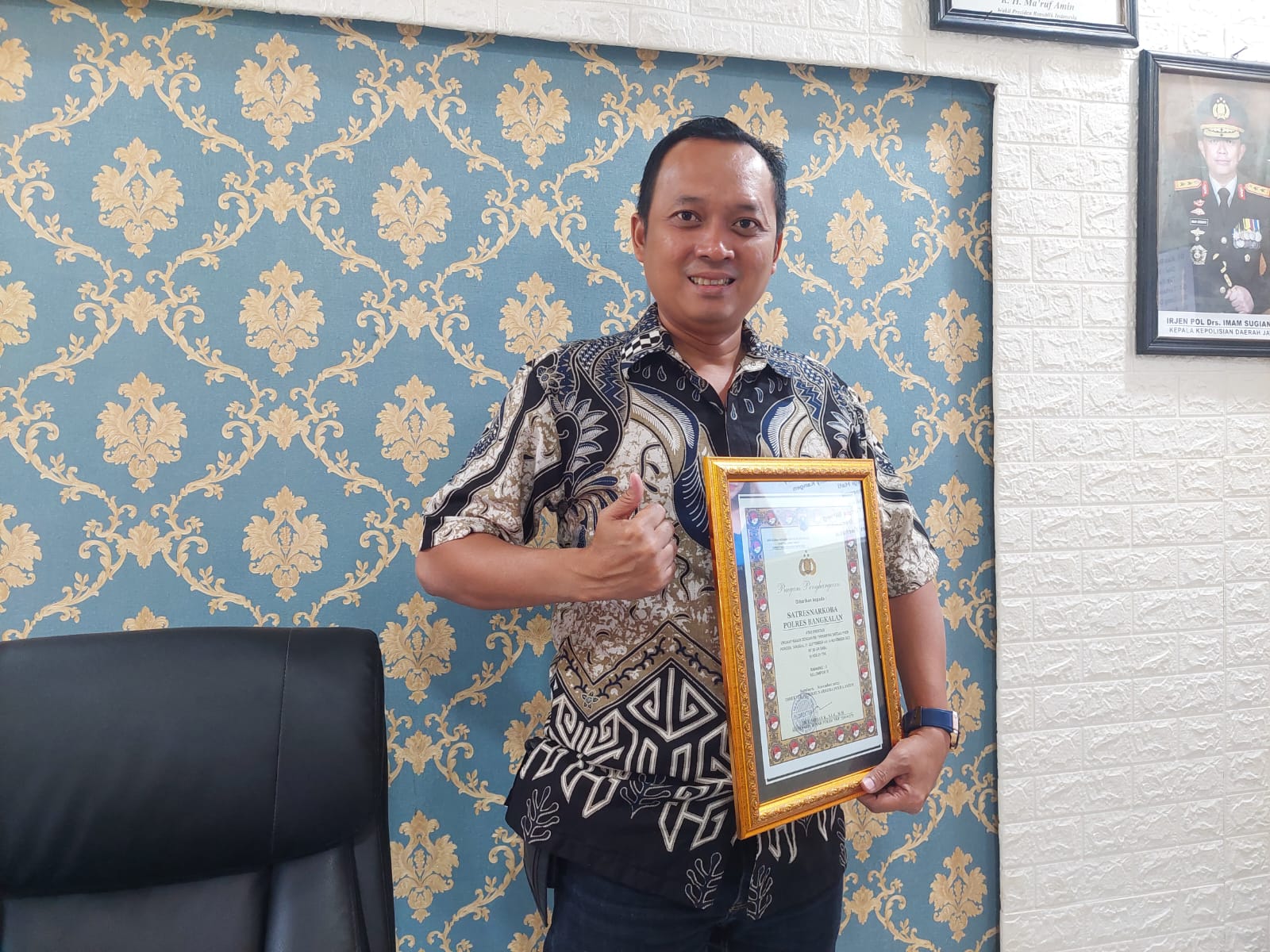 BERPRESTASI: Kasatnarkoba Polres Bangkalan menunjukkan piagam penghargaan yang diraihnya di ruang kerjanya, Jumat (22/12). (ZEINAL ABIDIN/JPRM)