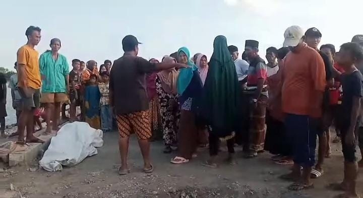 SITA PERHATIAN: Warga Desa Karamian, Kecamatan Masalembu, menyaksikan mayat Rusli, korban KM Labobar yang tenggelam di perairan Karamian, Kamis (21/12). (JAILANI UNTUK JPRM)