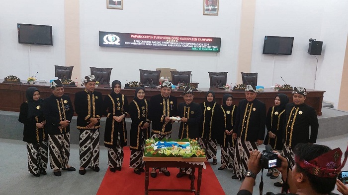 SIMBOLIS: Ketua DPRD Sampang Fadol (enam dari kanan) menyerahkan potongan tumpeng kepada bupati usai sidang paripurna memperingati Hari Jadi Ke-400 Kabupaten Sampang di kantor dewan Sabtu (23/12).
