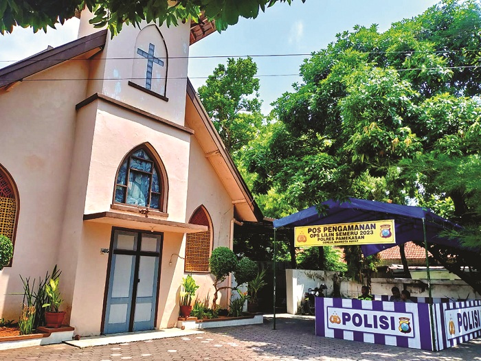 BERTUGAS: Tim gabungan Polres Pamekasan bertugas menjaga keamanan di area pospam di GPIB Jemaat Mahkota Hayat, Jalan Jokotole, Jumat (22/12). (UBAIDILLAHIR RA&rsquo;IE/JPRM)