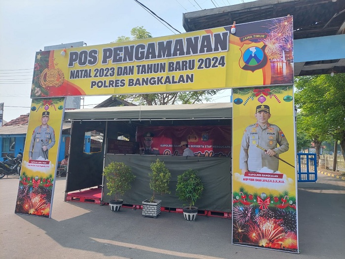 DIJAGA KETAT: Anggota Polres Bangkalan bertugas di pos pengamanan Natal 2023 di Pelabuhan Kamal, Jumat (22/12). (ZEINAL ABIDIN/JPRM)