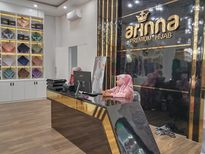 SIAP MELAYANI: Karyawan Arinna Premium Hijab berjaga di store yang berada di Jalan Adirasa, Desa Kolor, Kecamatan Kota Sumenep, pada Kamis (21/12