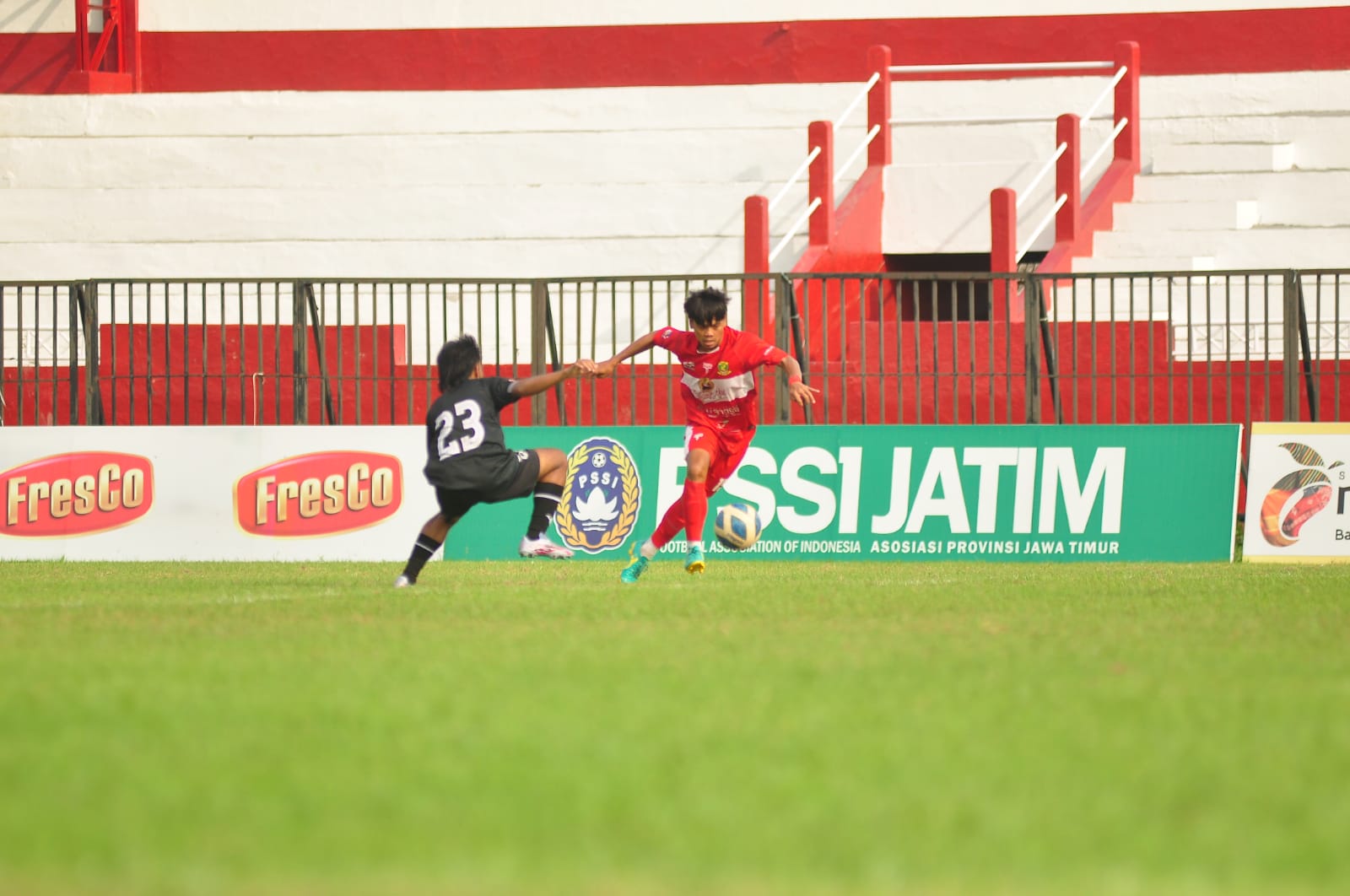 MENGECOH: Pemain Perssu Madura City (merah) berusaha melewati pemain Persepam Pamekasan saat bertanding di Stadion A. Yani Sumenep, Minggu (17/12). (PERSSU MC UNTUK JPRM)