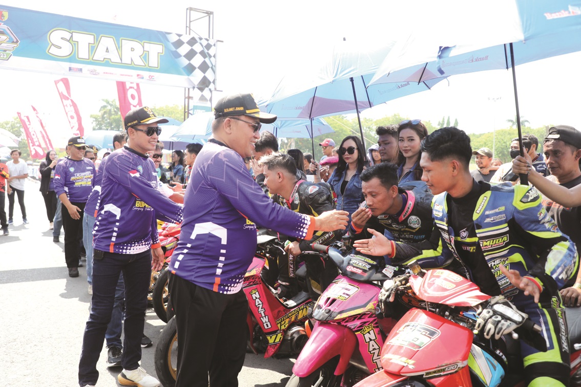 MERIAH: Bupati Sampang Slamet Junaidi didampingi Wabup Abdullah Hidayat menyalami peserta road race di Alun-Alun Trunojoyo, Minggu (24/12). (PROKOPIM SAMPANG UNTUK JPRM)