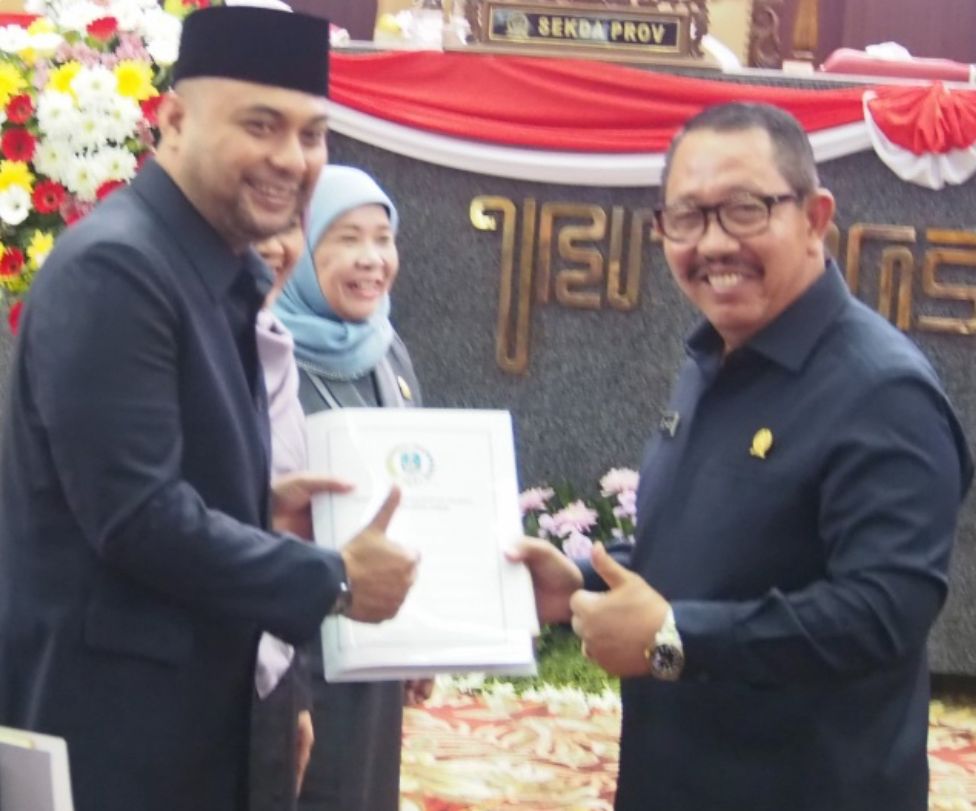 SELESAI: Komisi C DPRD Jatim Abdul Halim menyerahkan berkas pengesahan perda
