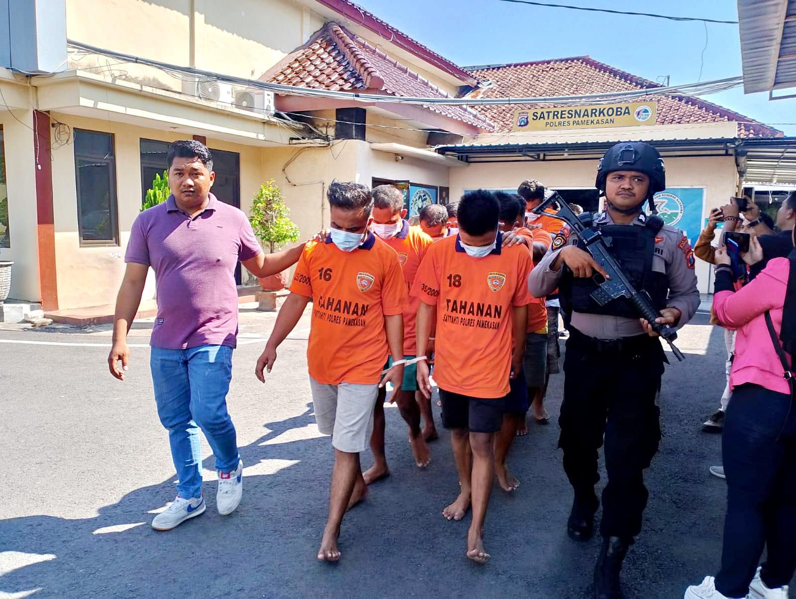 DIKAWAL KETAT: Tersangka penyalahgunaan narkoba dikawal ketat oleh anggota Polres Pamekasan di halaman mapolres, Jumat (29/12).