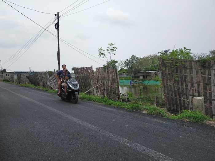 TUNGGU REGULASI: Warga melintas di area tambak, Jalan Maritim, Kecamatan Socah, Bangkalan, Selasa (28/11/23). (VIVIN AGUSTIN HARTONO/JPRM)