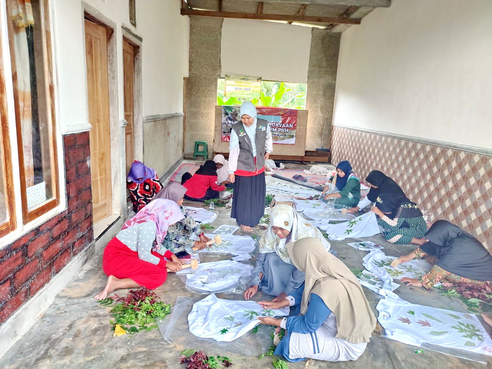 MEMBIMBING: Pendamping PKH Kadur Fatmawati mengontrol pembuatan ecoprint yang diikuti oleh KPM Kecamatan Kadur, Pamekasan, Minggu, (31/12/2023). (LAILIYATUN NURIYAH/JPRM)