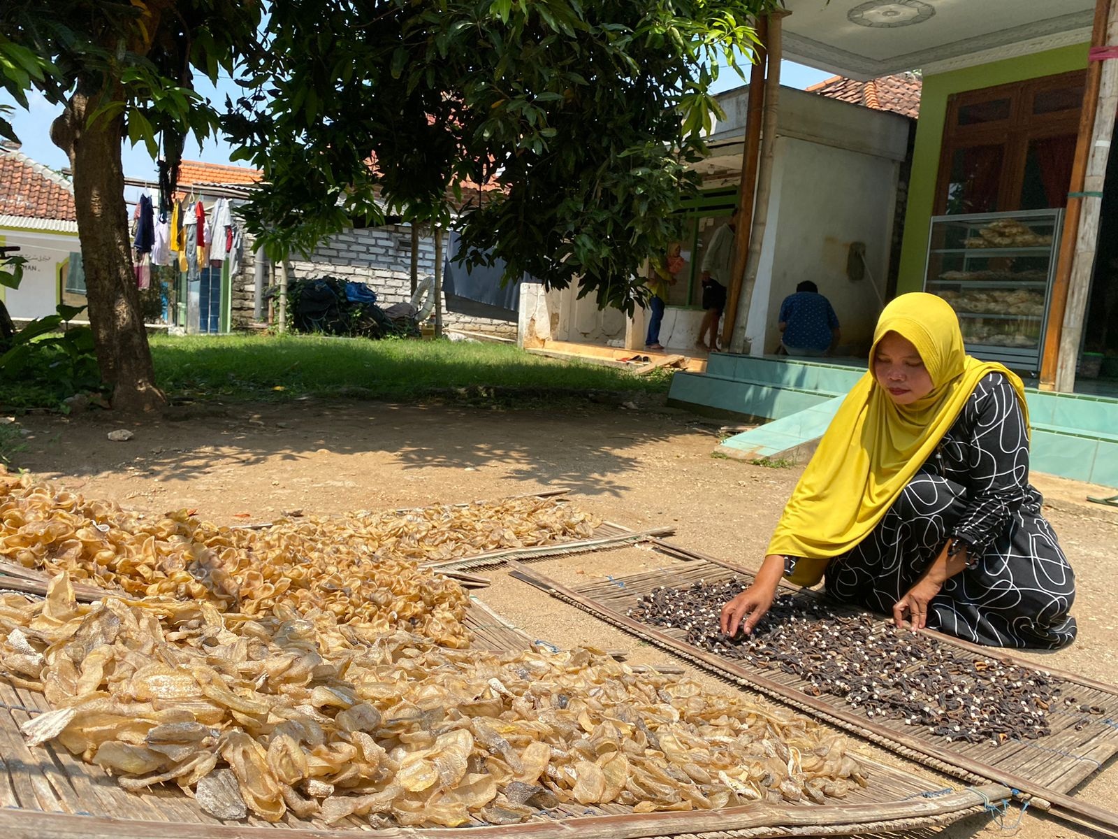 KREATIF: Seorang istri nelayan menjemur terung sebelum diolah menjadi kerupuk di Desa Junganyar, Kecamatan Socah, Sabtu (16/12/2023). (AYU LATIFAH/JPRM)