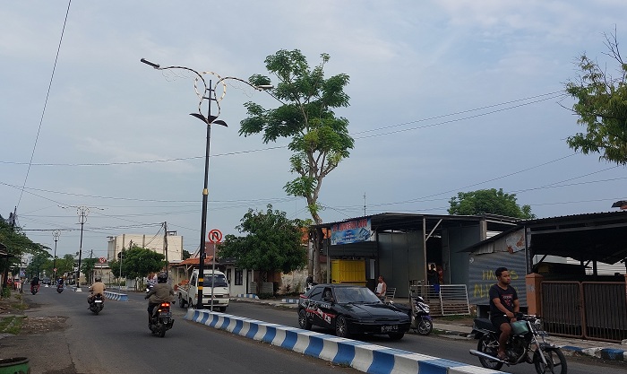 JALUR UTAMA: Pengendara melintas di sekitar lampu PJU yang berada di Jalan Syamsul Arifin, Kota Sampang, Sabtu (6/1). (JUNAIDI PODNIYANTO/JPRM)