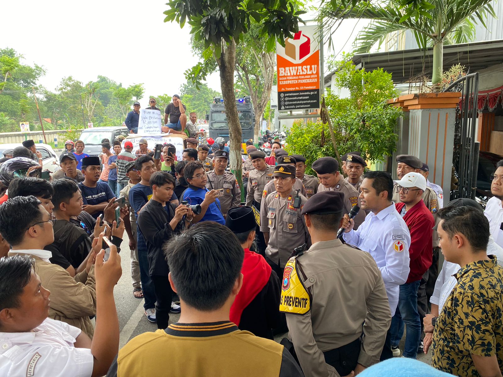 BERJANJI: Ketua Bawaslu Pamekasan Sukma Umbara Tirta Firdaus (putih) saat menemui peserta aksi, Rabu (10/1). (MOH. JUNAIDI/JPRM)