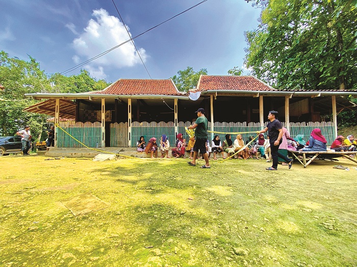 TELITI: Petugas memasang garis polisi di rumah korban yang terletak di Dusun Lorpolor, Desa Karanggayam, Kecamatan Omben, Sampang, Selasa (9/1). (MOH. IQBAL AFGANI/JPRM)
