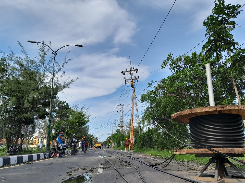TEKNISI PROFESIONAL: Petugas PLN memperbaiki jaringan listrik di Jalan Trunojoyo, Desa Patean, Kecamatan Batuan, yang bermasalah akibat terkena angin puting beliung, Rabu (10/1). (MOH. BUSRI/JPRM)