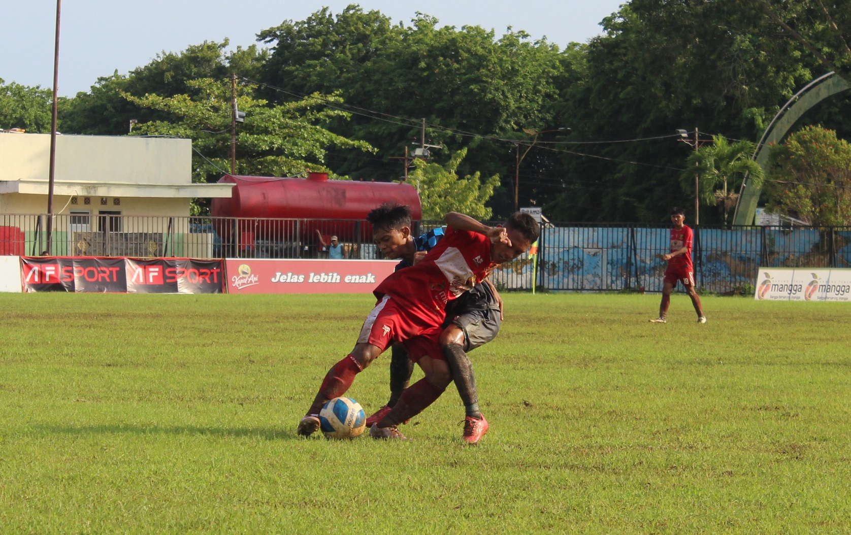 BERSAING SENGIT: Pemain Perssu MC (merah) dihadang pemain Pasuruan United di Stadion A. Yani Sumenep, Selasa (9/1). (MUHAMAD ERWIN MAULIDIN M/JPRM)
