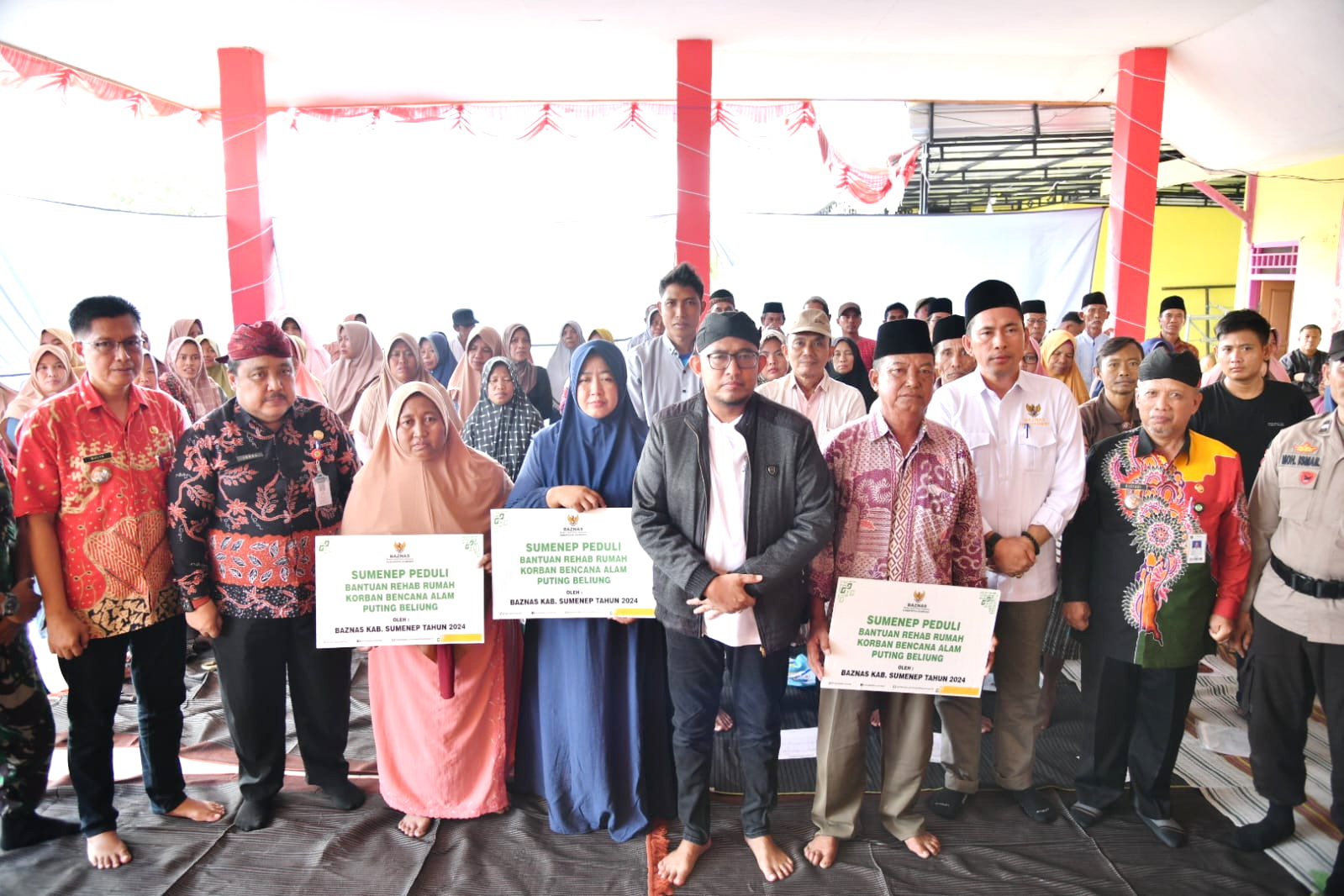 PEDULI: Bupati Sumenep Achmad Fauzi Wongsojudo berfoto bersama korban terdampak angin puting beliung setelah memberikan bantuan stimulan di Balai Desa Nambakor, Kecamatan Saronggi, Kamis (11/1).