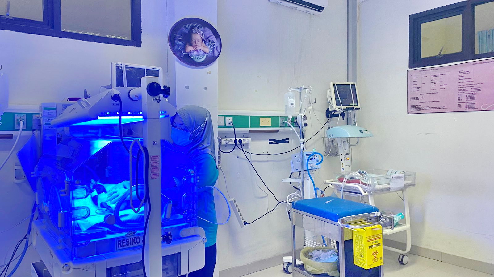 SEHAT: Tenaga kesehatan Neonatus RSUD Syamrabu Bangkalan mengecek kondisi bayi terapi sinar di ruang bayi, Jumat (12/1). (AYU LATIFAH/JPRM)