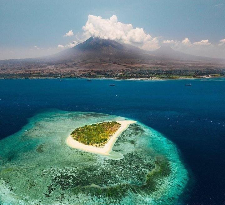 Pemandangan Pulau Tabuhan&nbsp; yang di dokumentasi dari kejauhan dilengkapi dengan indahnya pemandangan pegunungan (@ayodolan untuk RadarMadura.id)