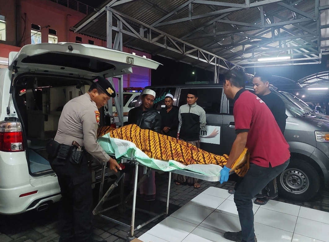 TURUNKAN: Petugas menurunkan jenazah untuk dilakukan autopsi di RSUD Syamrabu Bangkalan.