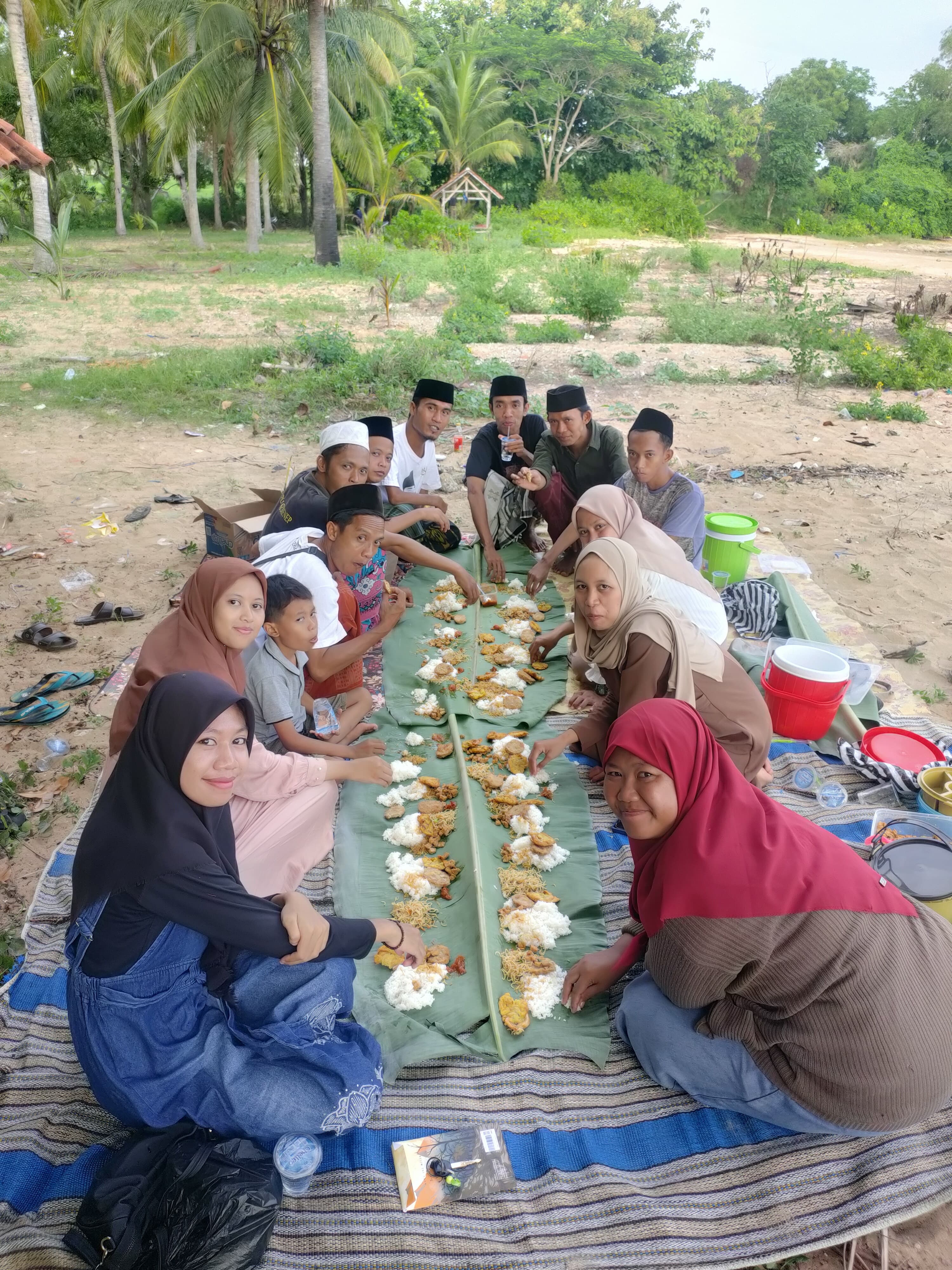 DUDUK SAMA RATA: Anggota makan bersama setelah merayakan satu tahun Komunitas DK di Pantai Bintaro, Kecamatan Gapura, Sumenep, Sabtu (13/1).