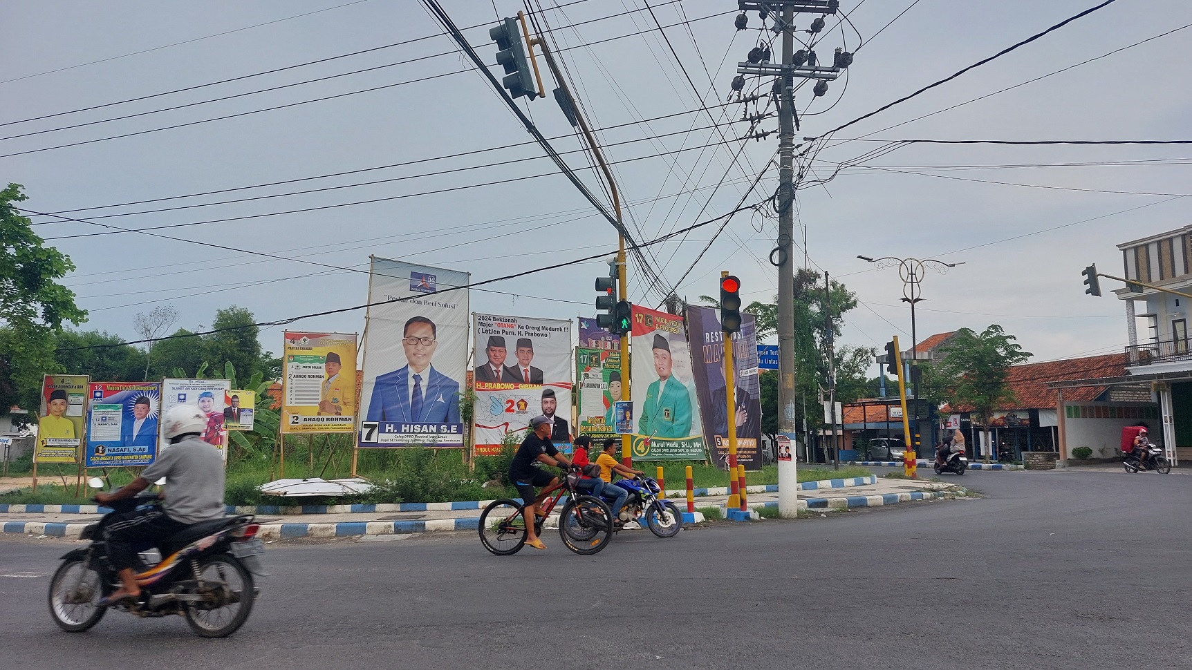 SERAHKAN LADK: Pengendara melewati alat peraga kampanye sejumlah bacaleg di Jalan Rajawali, Sampang, Minggu (14/1). (JUNAIDI PONDIYANTO/JPRM)