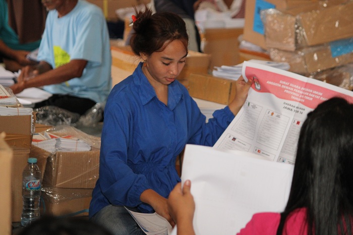 HATI-HATI: Pekerja melipat surat suara pemilu anggota DPRD Jawa Timur di gudang logistik KPU Bangkalan, Rabu (17/1). (VIVIN AGUSTIN HARTONO/JPRM)