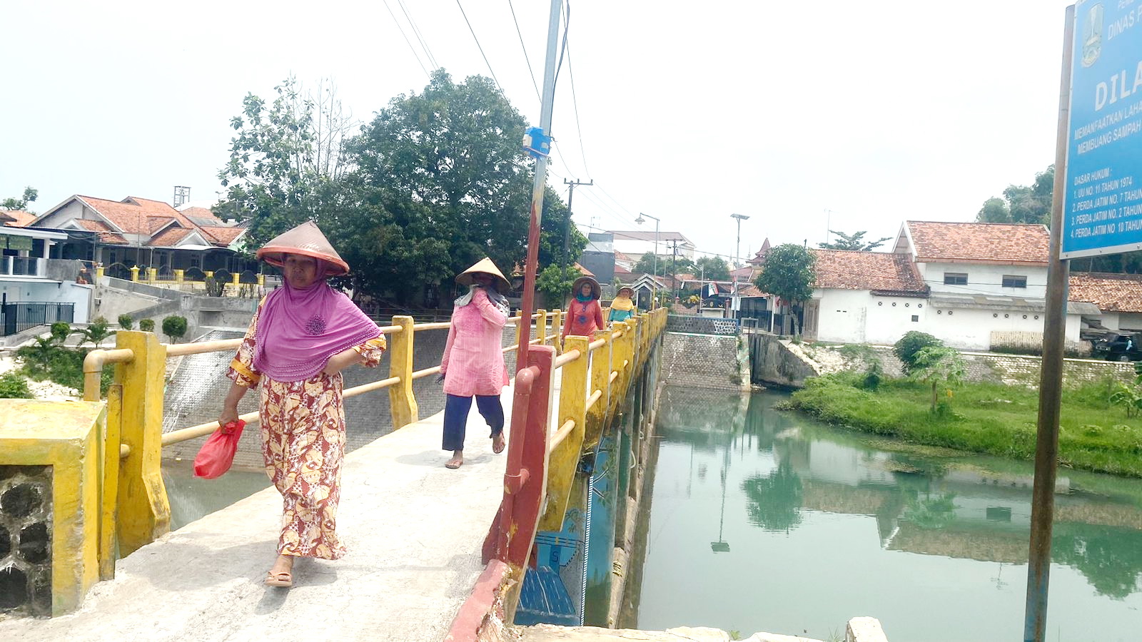 IKLH RENDAH: Empat perempuan melintas di DAM Kelurahan Tunjung, Kecamatan Burneh, Selasa (16/1). Pencemaran Lingkungan di Bangkalan tinggi. (AYU LATIFAH/JPRM)
