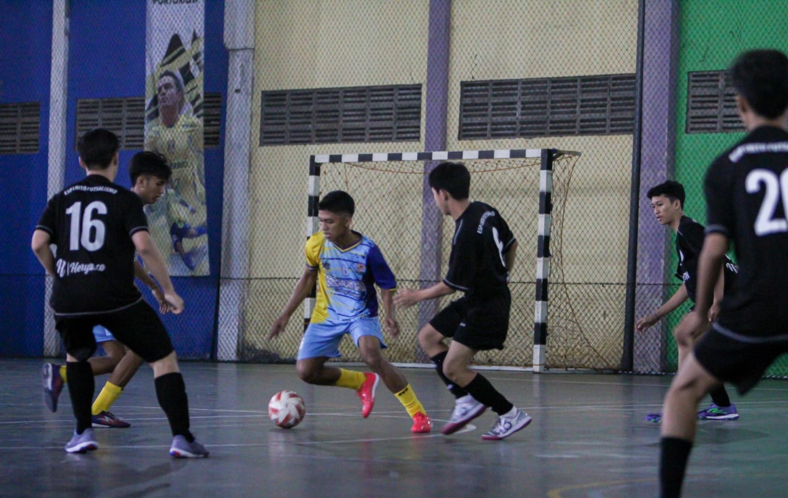 PERSIAPAN TURNAMEN: Pemain futsal Kabupaten Bangkalan berusaha melewati pemain Espirito Futsalismo dalam laga uji coba di GOR Saka pada Agustus tahun lalu. (R. TUFIK HIDAYAT UNTUK JPRM)