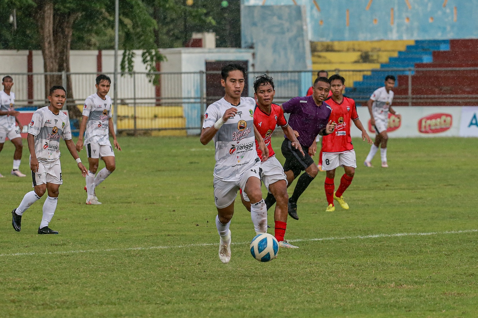 INCAR PELUANG: Pemain Perssu Madura City (putih) membangun serangan saat bertanding melawan Persiga Trenggalek di Stadion Untung Surapati Kota Pasuruan Kamis (18/1). (PERSSU MC UNTUK JPRM)