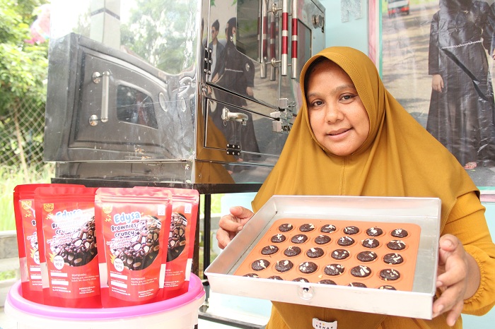 KREATIF: Marysa Ulfa menunjukkan hasil kue browniesnya setelah dioven di Desa Kebun, Kecamatan Kamal, Bangkalan, Sabtu (6/1). (VIVIN AGUSTIN HARTONO/JPRM)