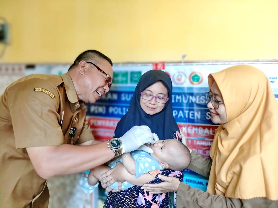 CEGAH POLIO: Kabid P2P Dinkes P2KB Sumenep Achmad Syamsuri (kiri) melakukan vaksinasi terhadap anak yang menjadi sasaran program PIN polio di Kecamatan Kota Sumenep. (DINKES P2KB SUMENEP UNTUK JPRM)