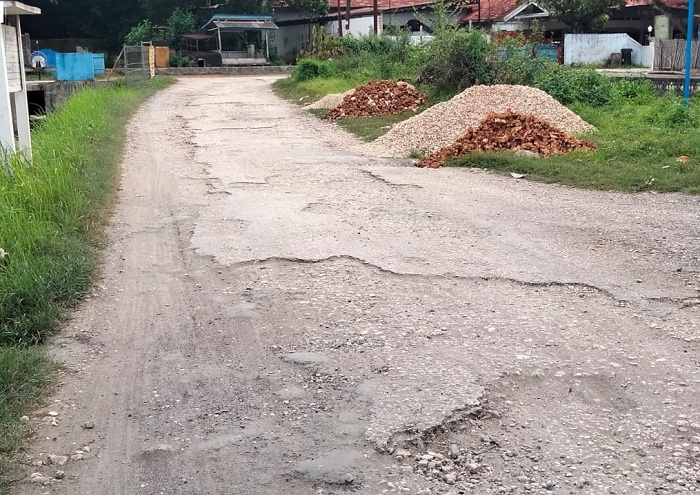 BUTUH PERHATIAN PEMERINTAH: Pengadaan material dari hasil dana urunan masyarakat sudah tersedia untuk perbaikan jalan penghubung empat desa di Lenteng, Sumenep, Rabu (24/1). (MOH. BUSRI/JPRM)