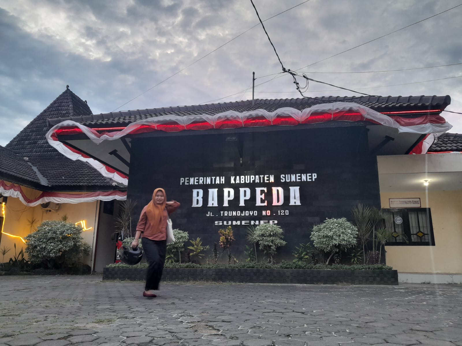 SEPI: Warga berjalan di halaman kantor Bappeda Sumenep. (MOH. BUSRI/JPRM)