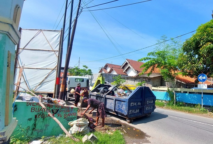 HARUS BERSIH: Petugas kebersihan mengangkut sampah dari tempat pembuangan sementara ke dalam truk di Jalan Rajawali, Kota Sampang, Kamis (25/1). (JUNAIDI PONDIYANTO/JPRM)